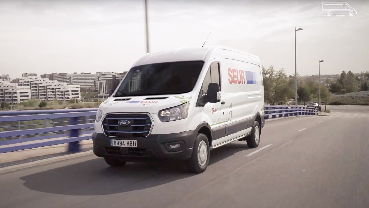 Ford E-Transit blanco conduciendo por la carretera