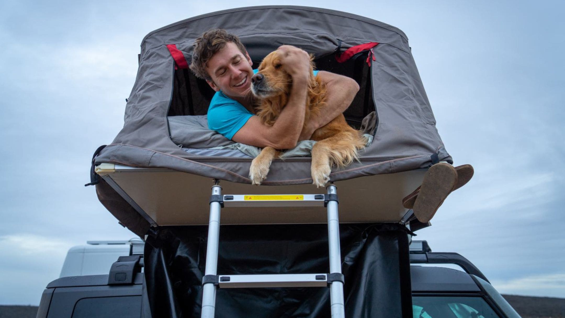 Hombre con su perro en la parte superior de un Ford