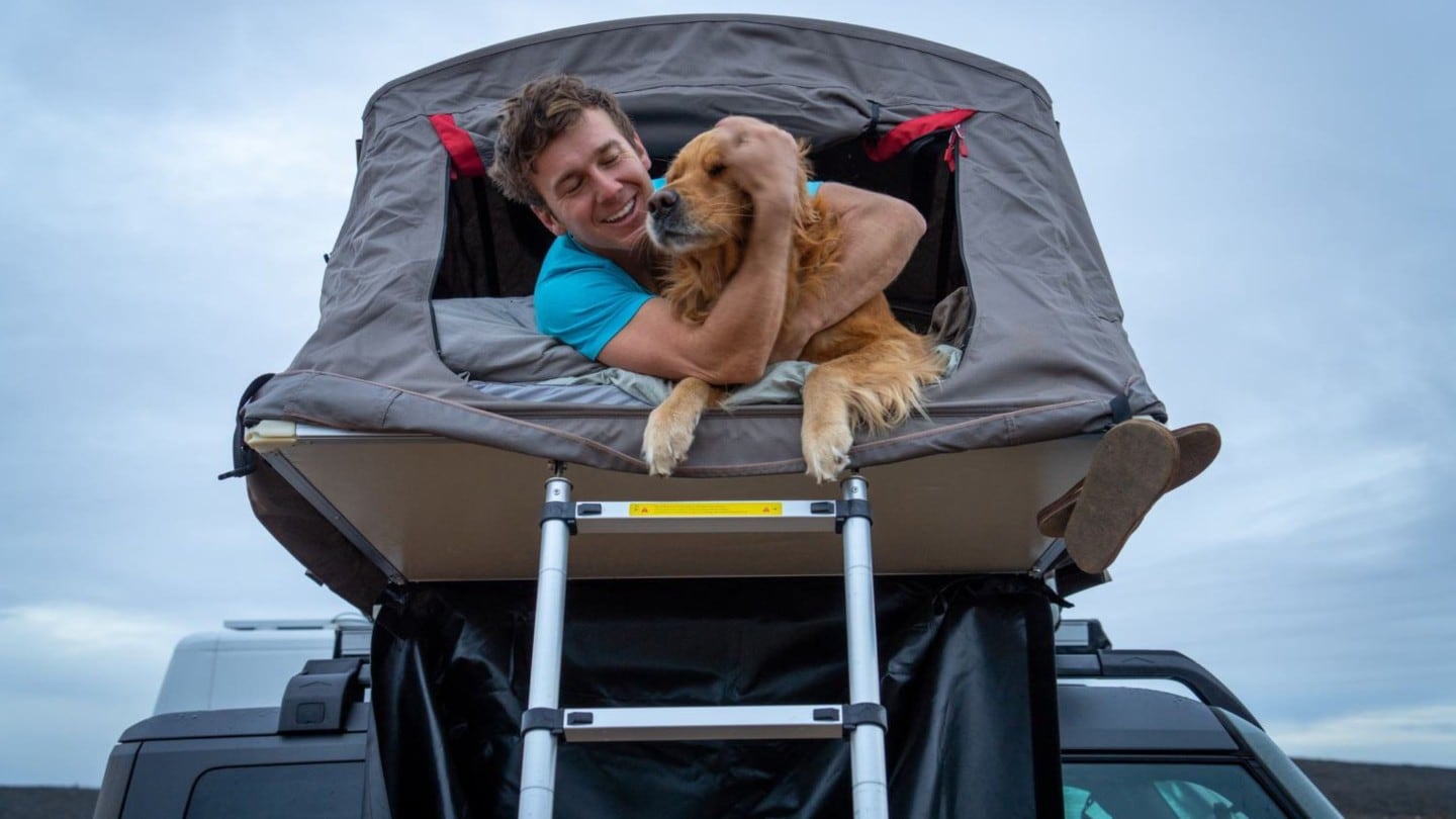 Hombre con su perro en la parte superior de un Ford
