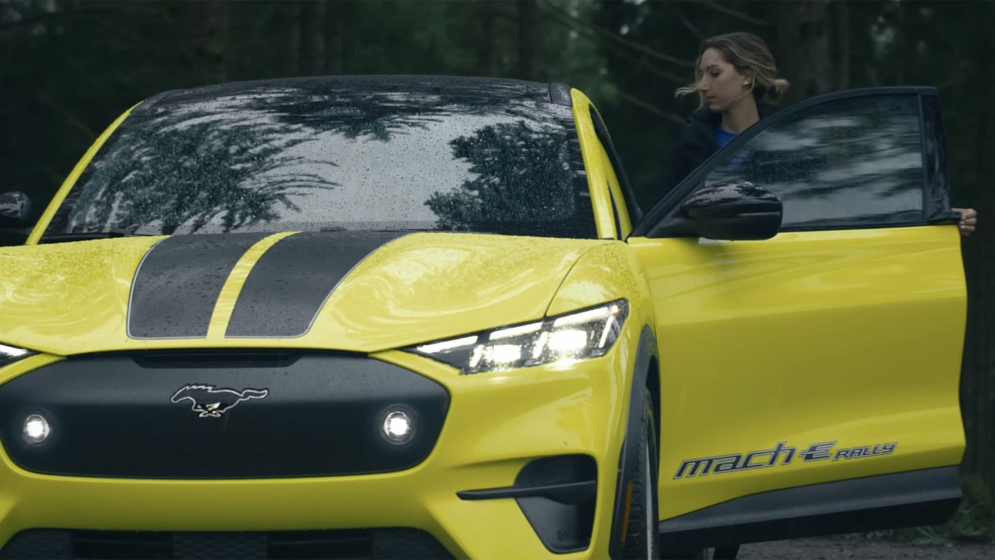 La campeona de bicicleta de montaña Savilia Blunk se sube a un Mustang Mach-E Rally amarillo.