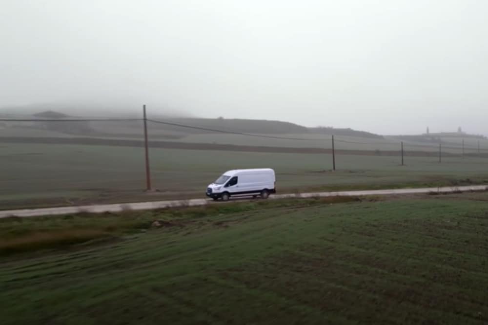 Ford E-Transit recorriendo carretera de campo