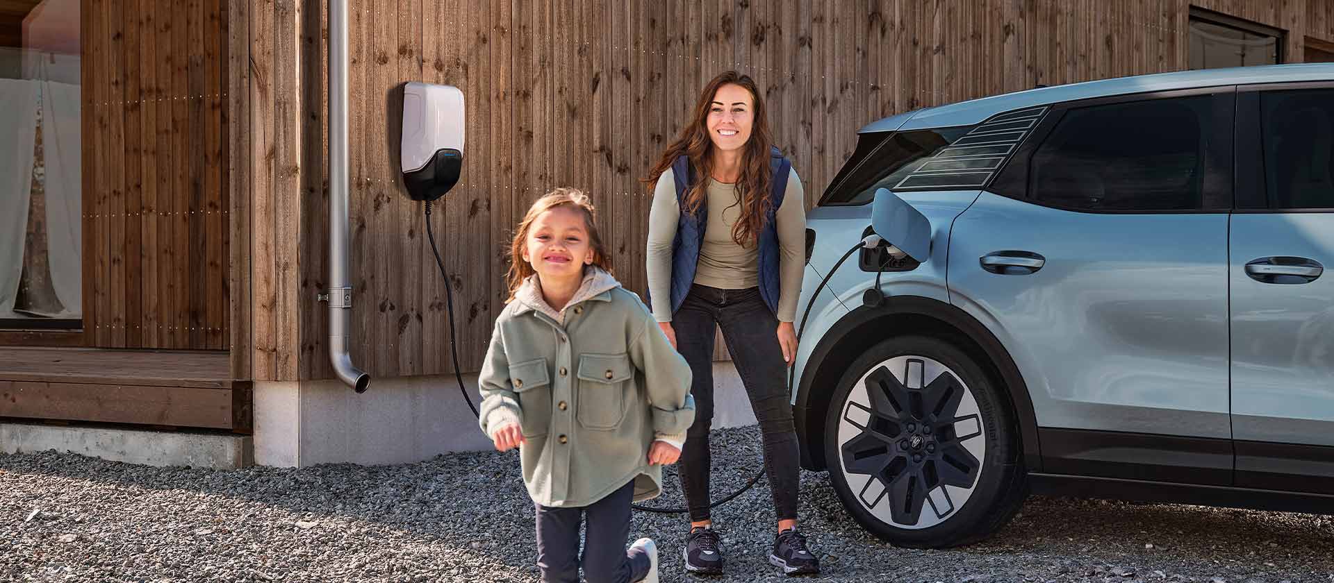 Una familia divirtiéndose mientras carga su Ford Explorer eléctrico con un cargador doméstico EV para exteriores.