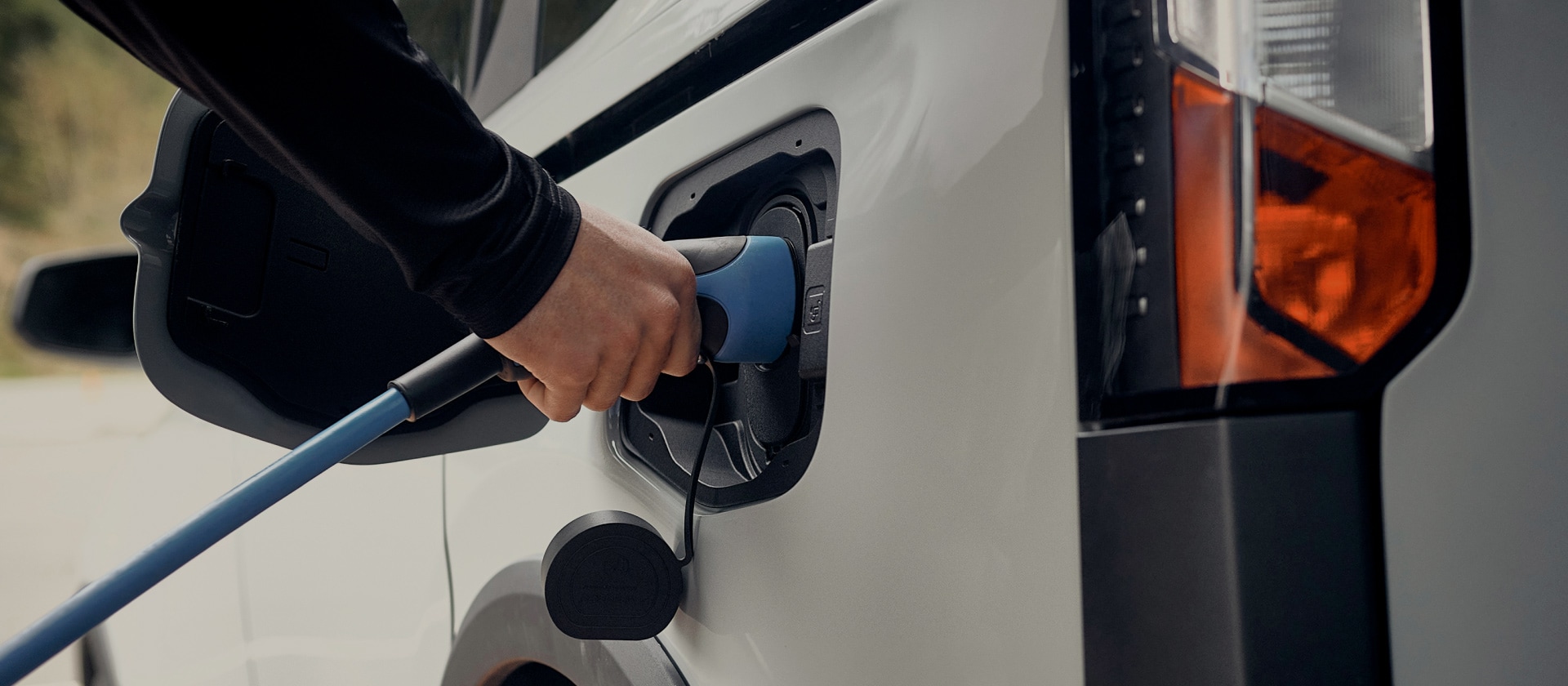 Primer plano de un vehículo eléctrico Ford blanco conectado a un cargador de vehículos eléctricos.