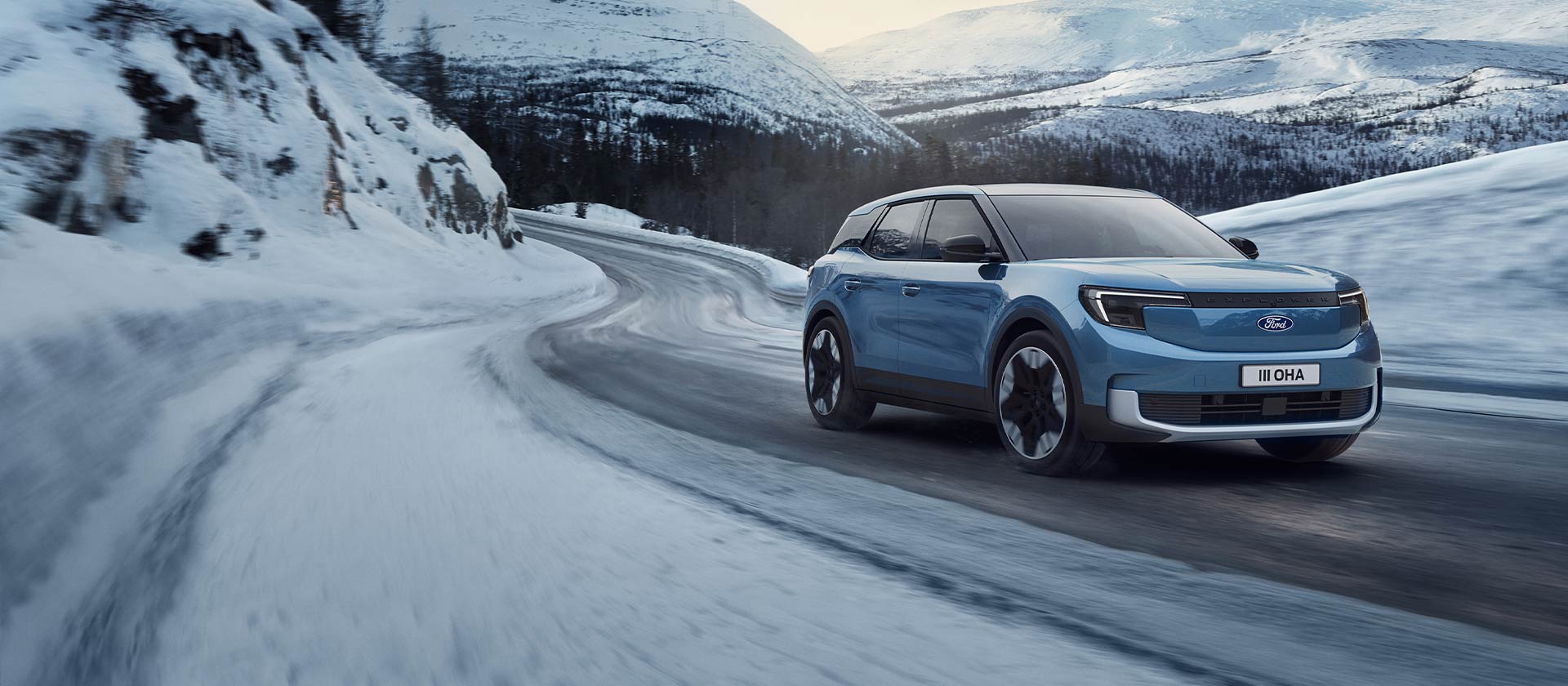 Ford Explorer eléctrico azul en una carretera de montaña nevada, destacando su capacidad y autonomía en condiciones invernales