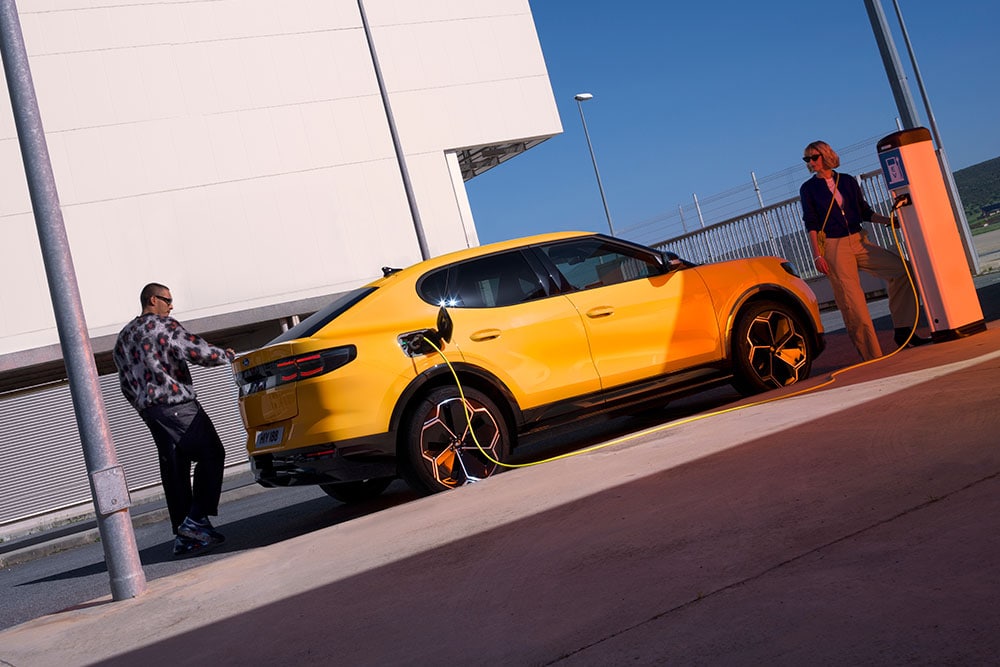 Ford Capri en amarillo cargándose en una estación de recarga pública