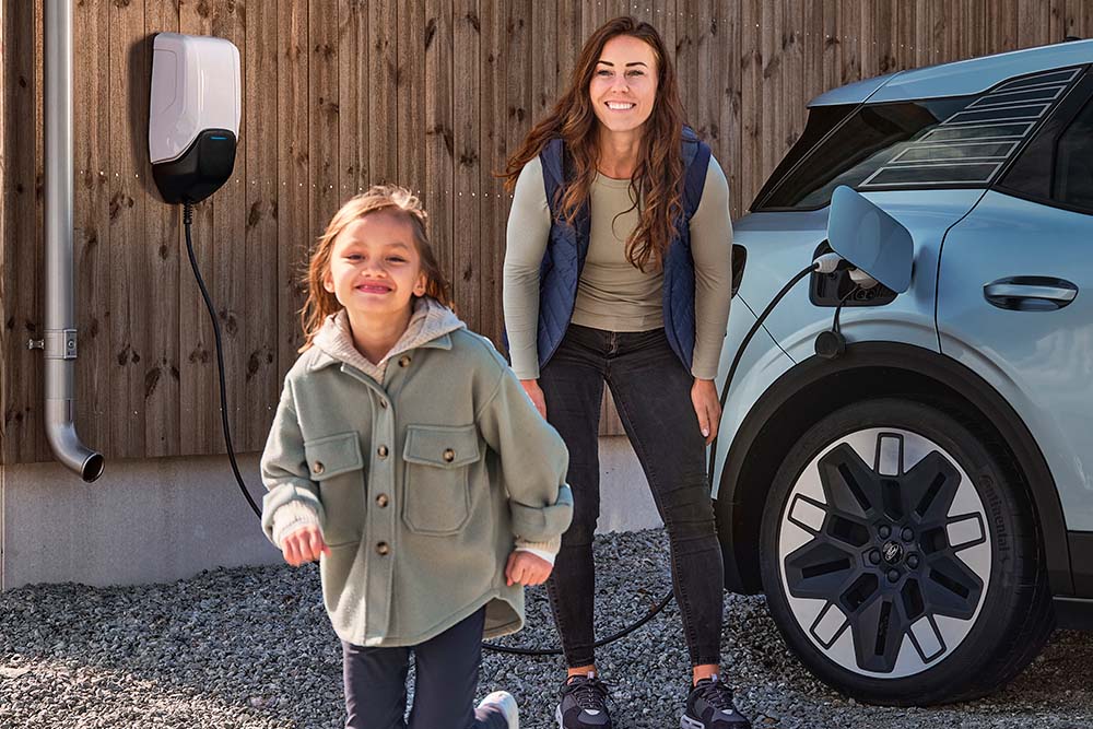 Una familia divirtiéndose mientras carga su Ford Explorer eléctrico en casa.