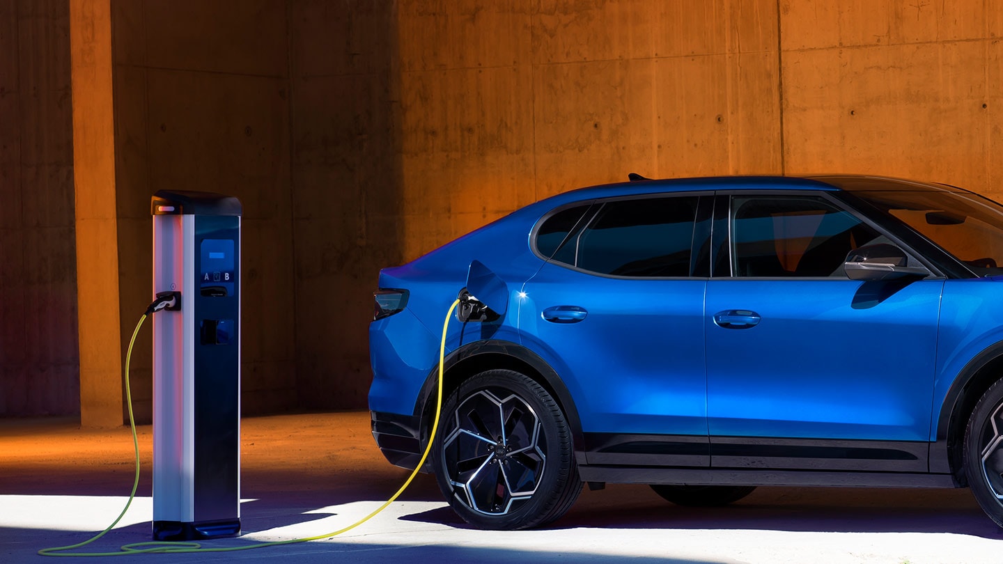 Un vehículo eléctrico Ford Capri azul conectado a un cargador de vehículos eléctricos.
