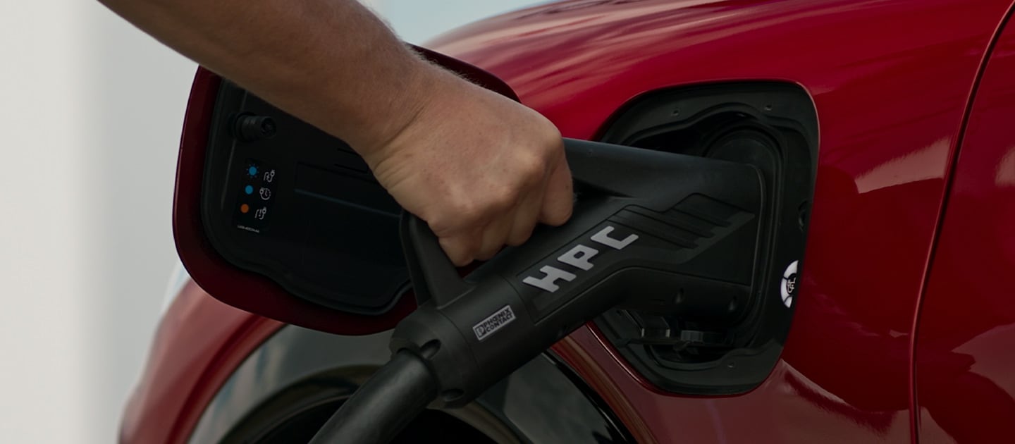 Primer plano de un Ford EV rojo conectado a un HPC (cargador de alta potencia) público, para una carga rápida de vehículos eléctricos públicos.