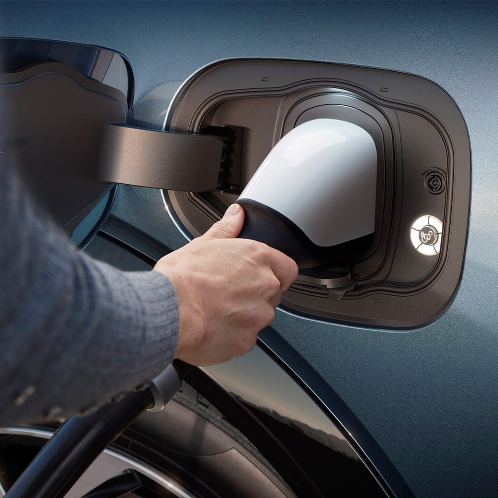 Una persona conectando un cargador EV ultrarrápido a un vehículo eléctrico Ford.