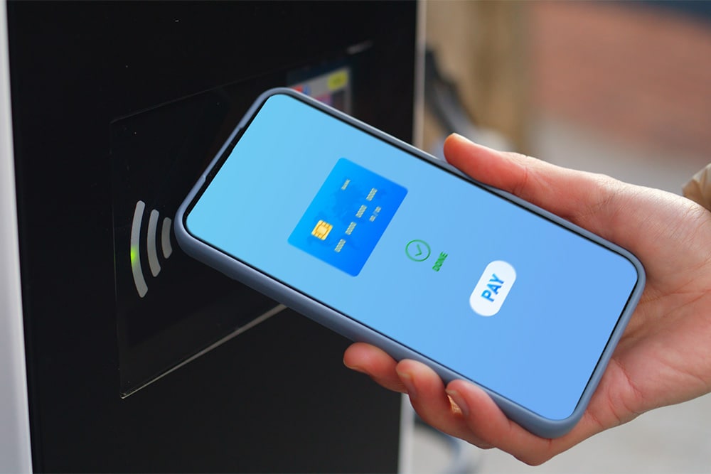 A smartphone being used at a public EV charging point for contactless payment.