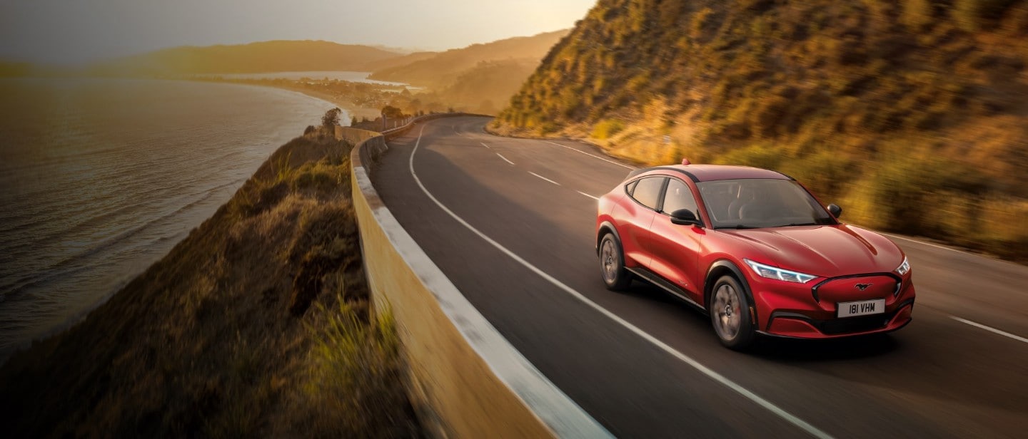 Red Mustang Mach-E on a coastal road