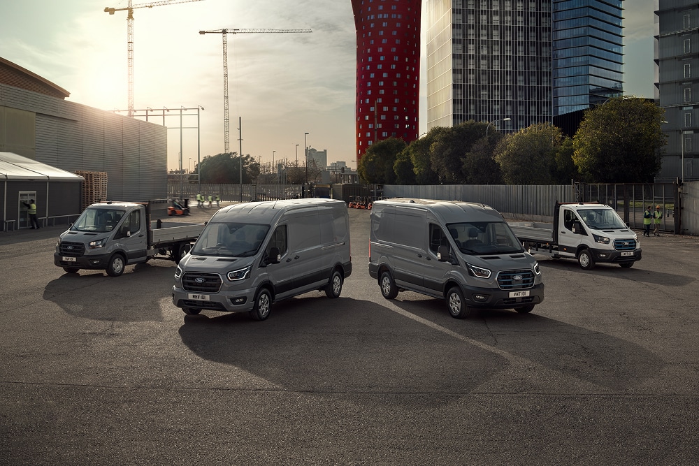 La gama de furgonetas eléctricas e híbridas enchufables de Ford estacionada un aparcamiento exterior.