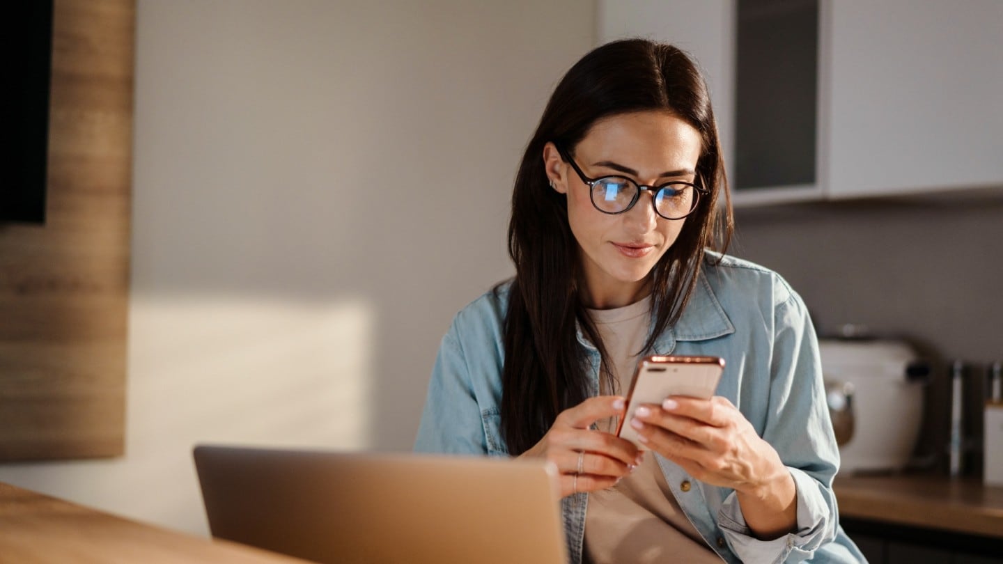 Mujer con teléfono revisando Ford Pro Telematics