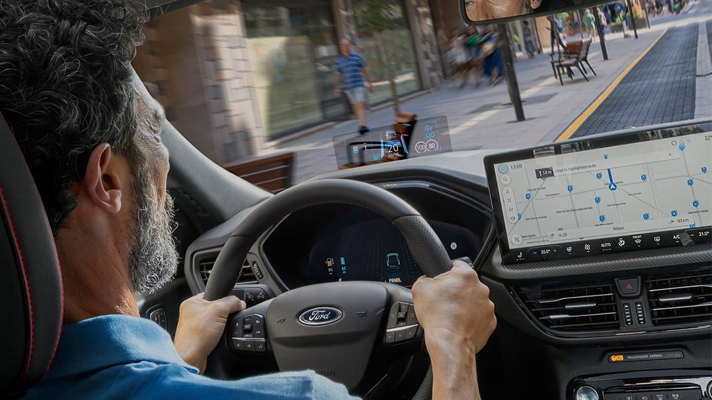 Foto del interior del Ford Kuga con un hombre conduciendo por una vía urbana.