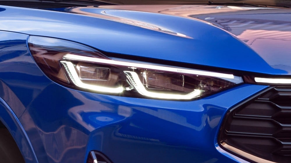 Primer plano del faro delantero de un Ford Mustang Mach-E azul.