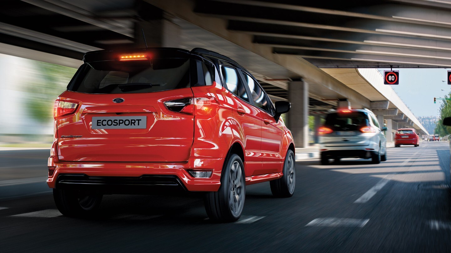 Ford EcoSport rojo conduciendo hacia una señal de tráfico