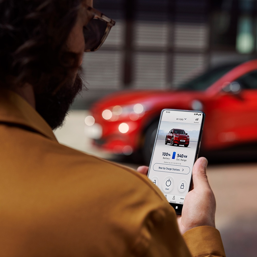 Man holding mobile with FordPass app
