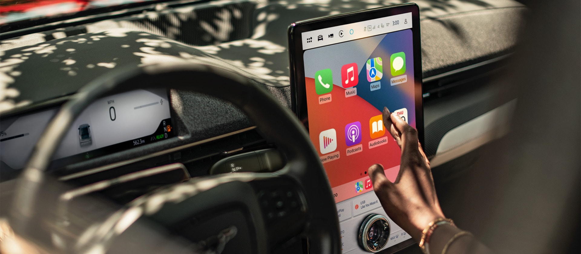 Un primer plano del conductor de un Ford Mustang Mach-E interactuando con la gran pantalla táctil SYNC 4 de 15,5" que muestra Apple CarPlay. 