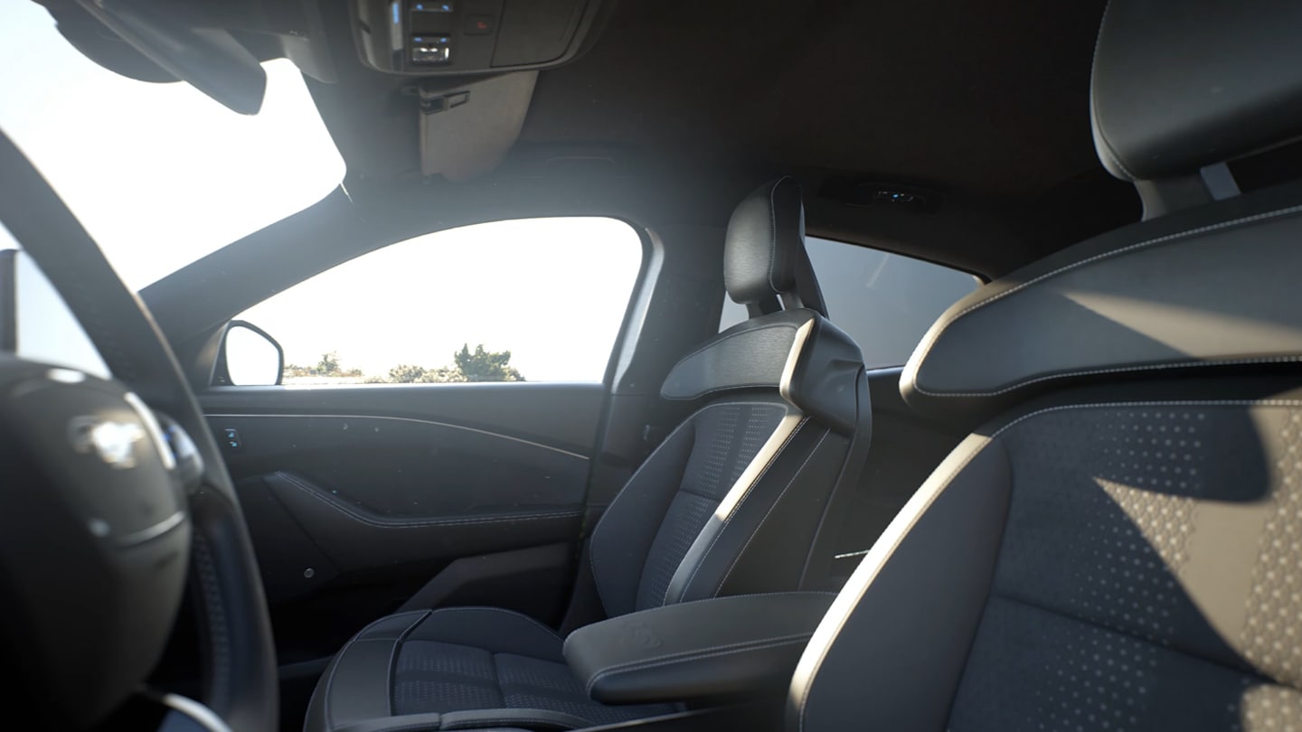 Una imagen del interior del Ford Mustang Mach-E que muestra los cinco cómodos asientos acabados en material negro con costuras rojas.