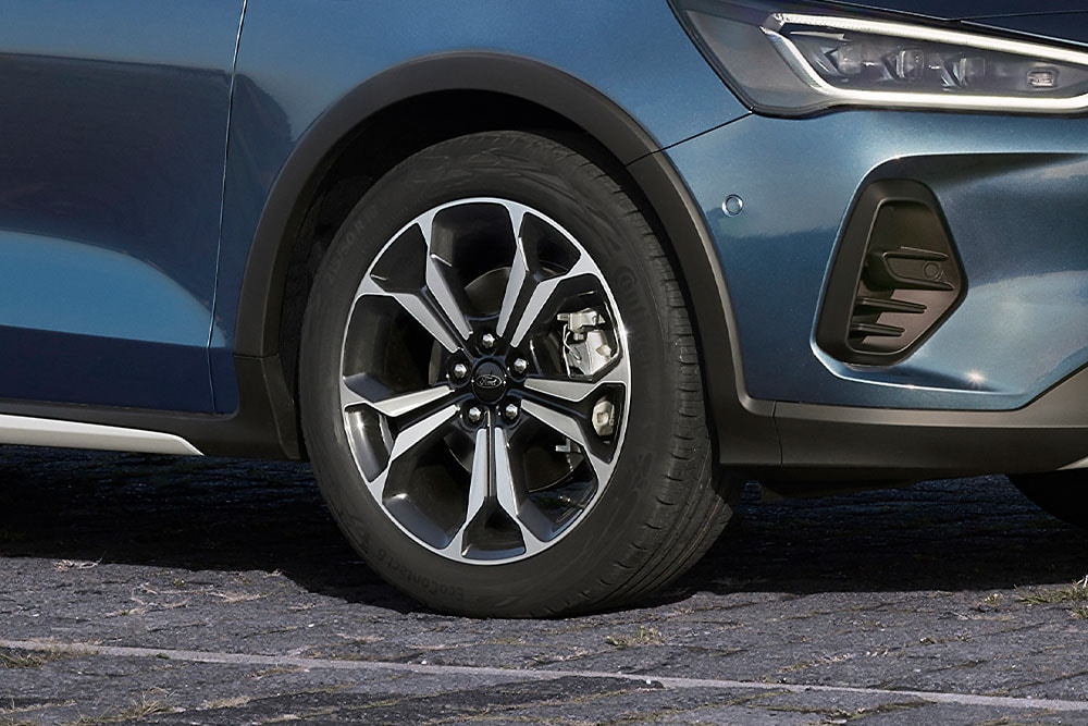 Un primer plano de las llantas de aleación del Ford Focus con un acabado gris oscuro y plateado.