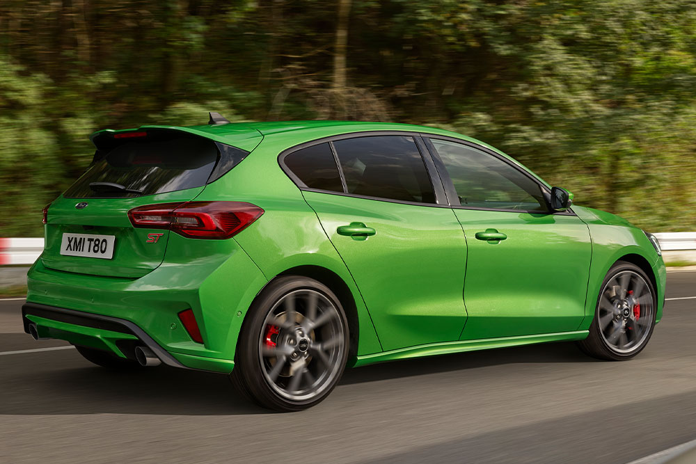 Vista trasera de un Ford Focus ST hatchback verde conduciendo en una pista de carreras.