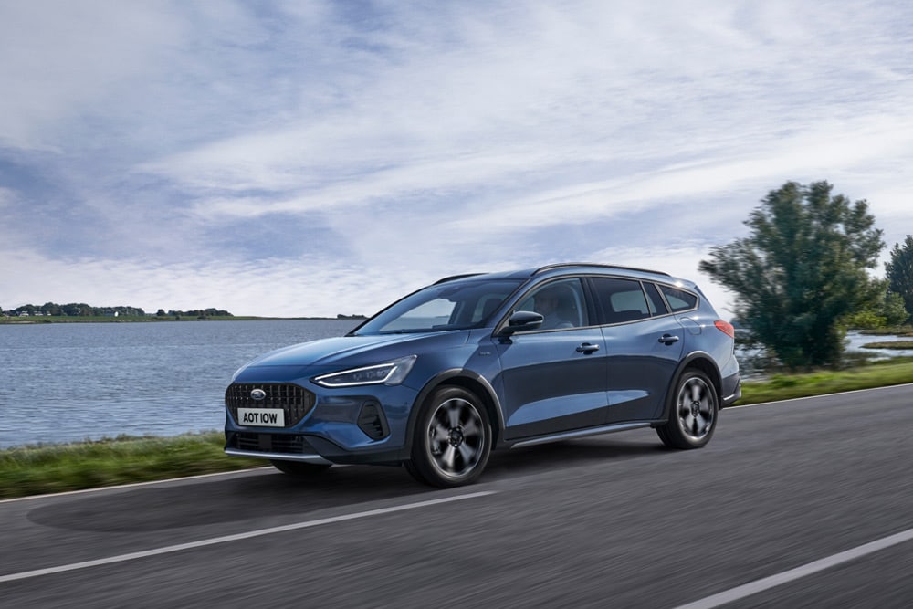 Imagen de un Ford Focus® Estate azul recorriendo una carretera junto a un lago.