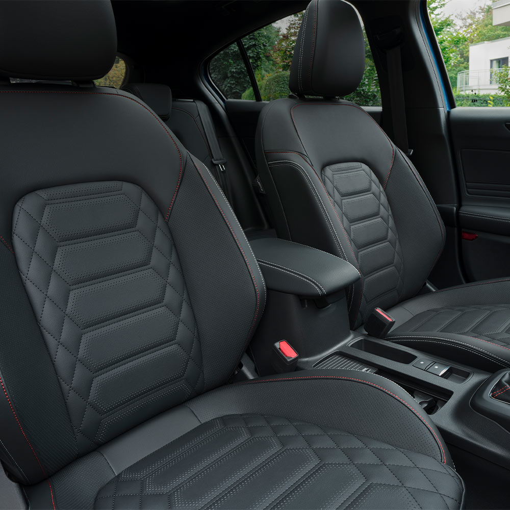 Vista interior del Ford Focus que muestra asientos Sensico negros con costuras rojas.