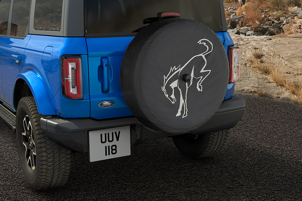 Vista trasera de un Ford Bronco azul con un neumático de repuesto montado en la parte trasera.