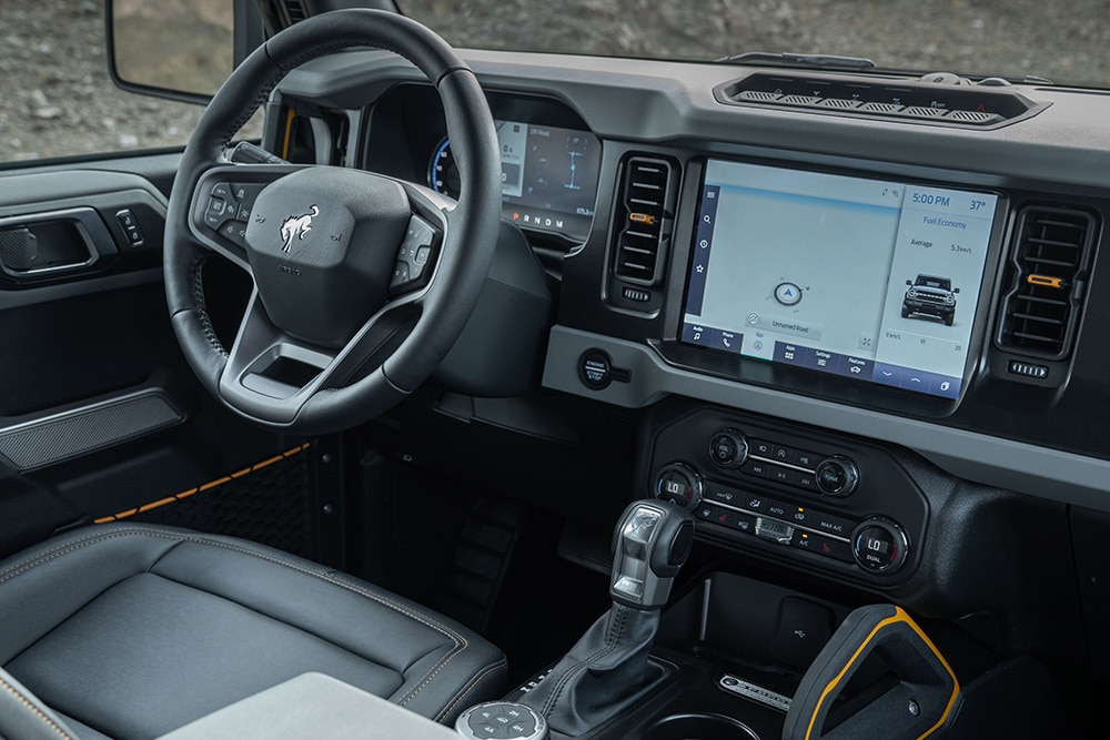 Vista del interior del Ford Bronco, incluido el volante de cuero y el panel táctil conectado.
