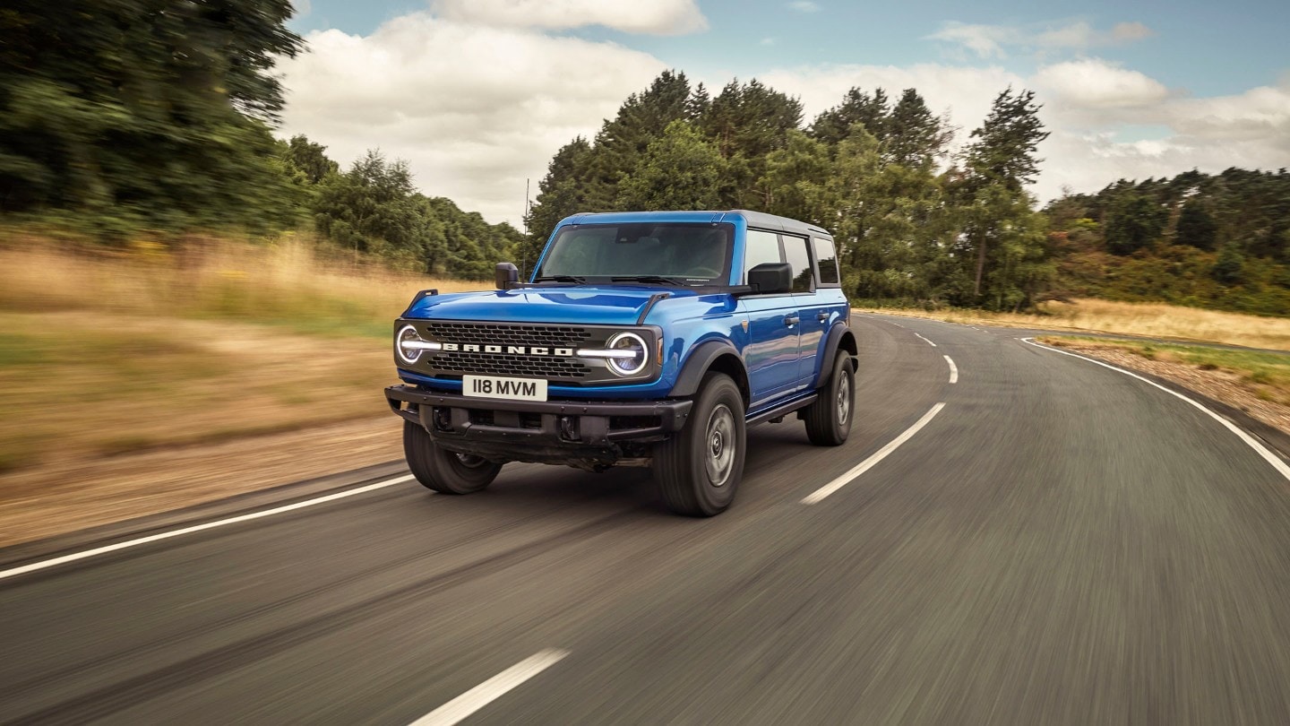 Ford Bronco conduciendo por una carretera de campo