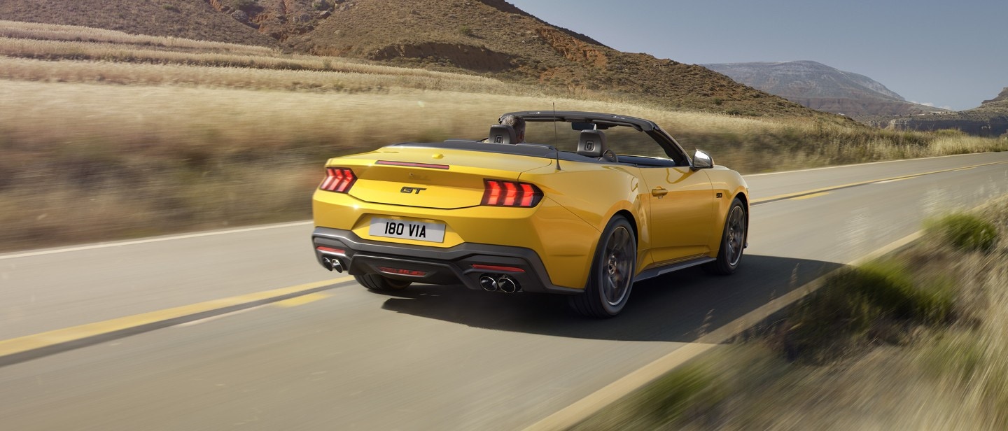 Yellow All-New Ford Mustang driving viewed from 3/4 back