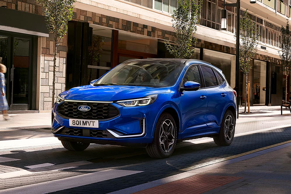 Un Ford Kuga ST Line de color Desert Island Blue aparcado en una zona residencial. 