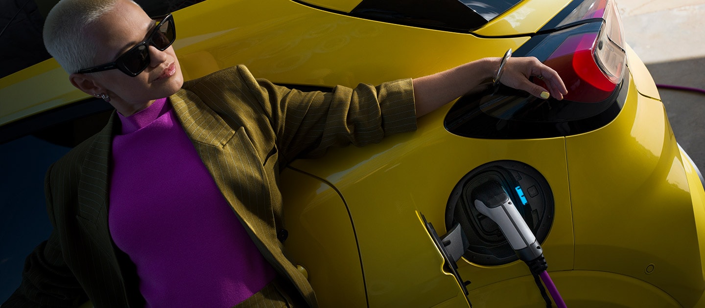 Primer plano de la parte trasera de un Ford Puma Gen-E® eléctrico enchufado a un cargador doméstico Wallbox.