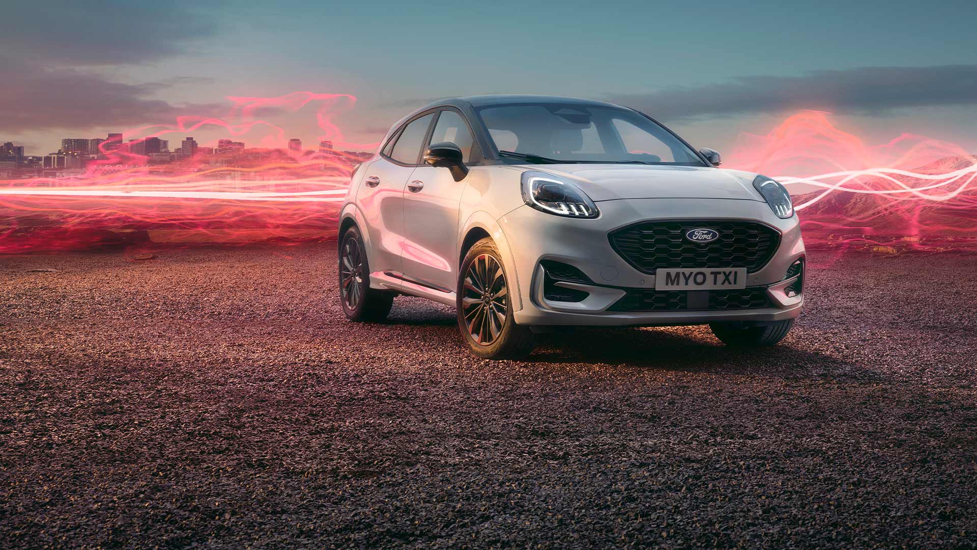 El modelo Ford Puma Sound Edition en color blanco, estacionado con gráficos de ondas sonoras en rojo de fondo.