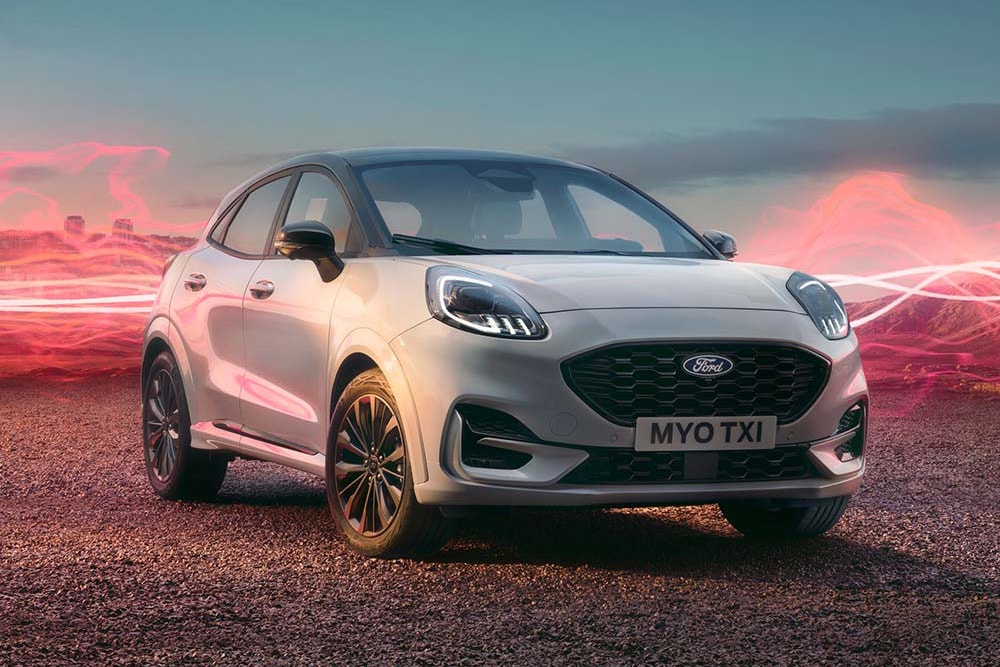 El modelo Ford Puma Sound Edition en color blanco, estacionado con gráficos de ondas sonoras en rojo de fondo.
