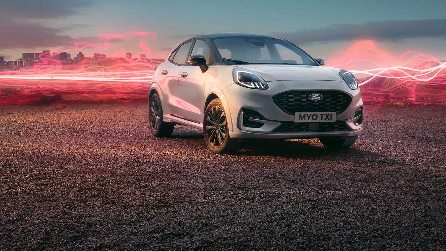 El modelo Ford Puma Sound Edition en color blanco, estacionado con gráficos de ondas sonoras en rojo de fondo.
