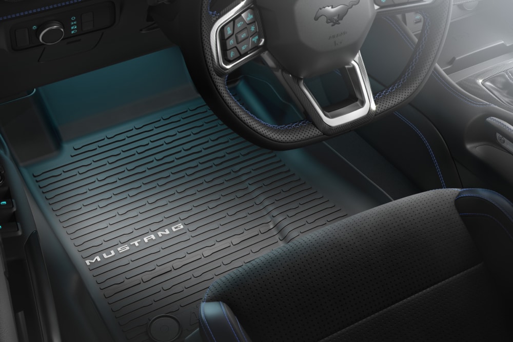Vista interior de un Ford Mustang en la que se aprecia el volante y una alfombrilla.