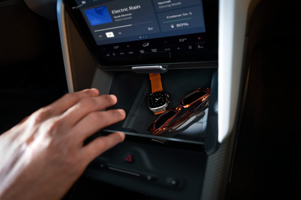 Una mano extendida hacia el compartimento My Private Locker del Ford Capri®, en cuyo interior puede apreciarse un reloj y un par de gafas de sol.