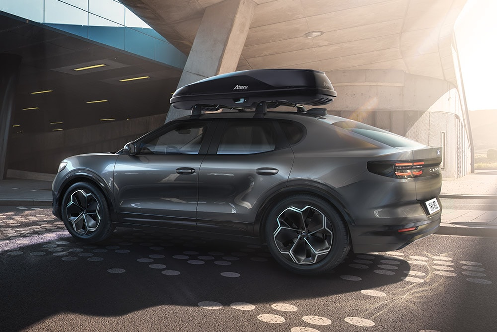 Ford Capri amarillo aparcado en una estructura de hormigón, vista trasera de una caja portaequipajes en la parte trasera con un portaequipajes.