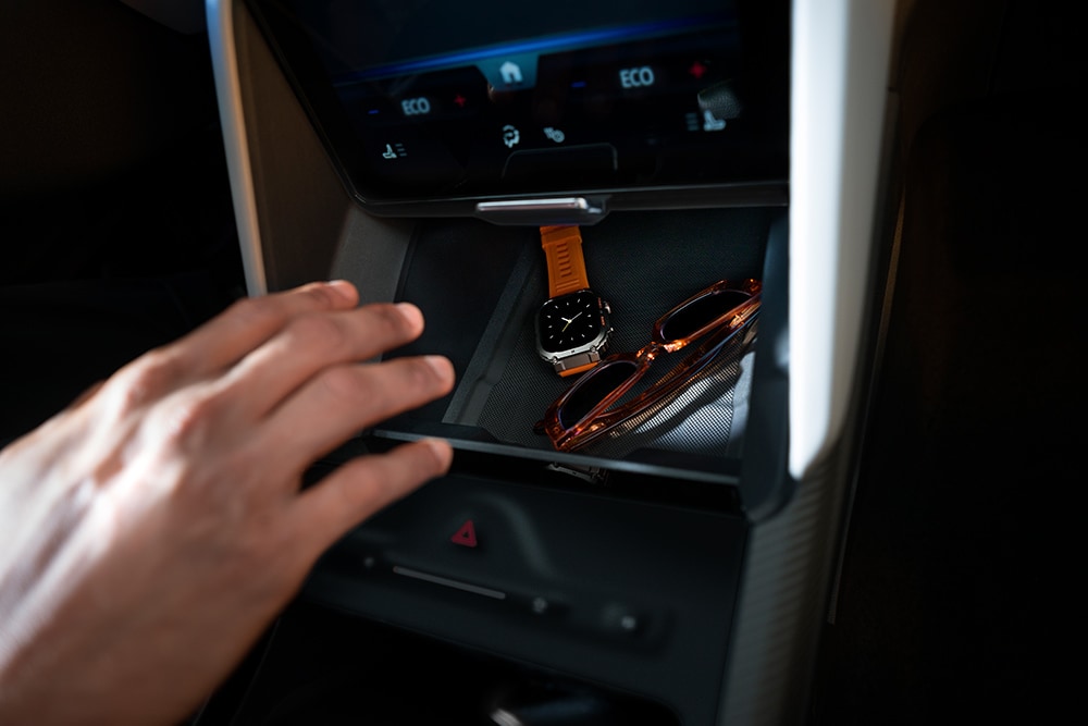 Una mano extendida hacia el compartimento My Private Locker del Ford Capri®, en cuyo interior puede apreciarse un reloj y un par de gafas de sol.