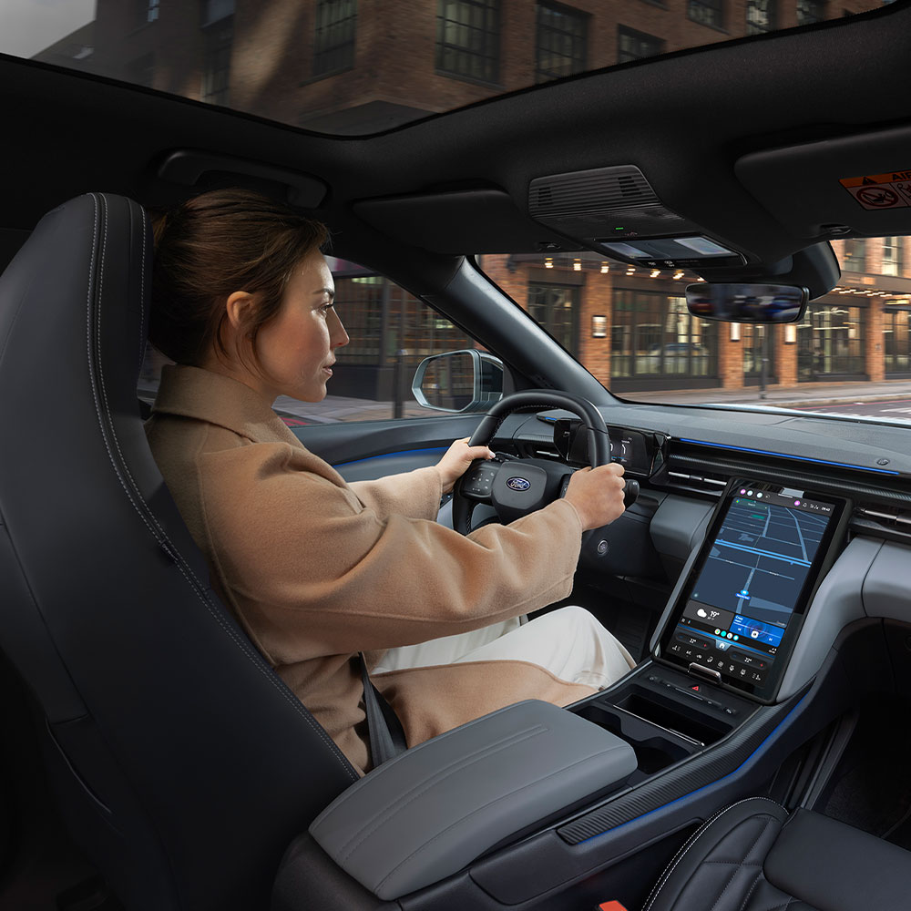Mujer conduce coche eléctrico