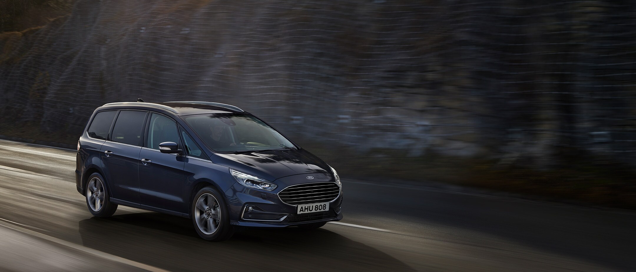 Ford Galaxy Titanium driving around the bend in city Ford Galaxy Titanium driving around the bend in city
