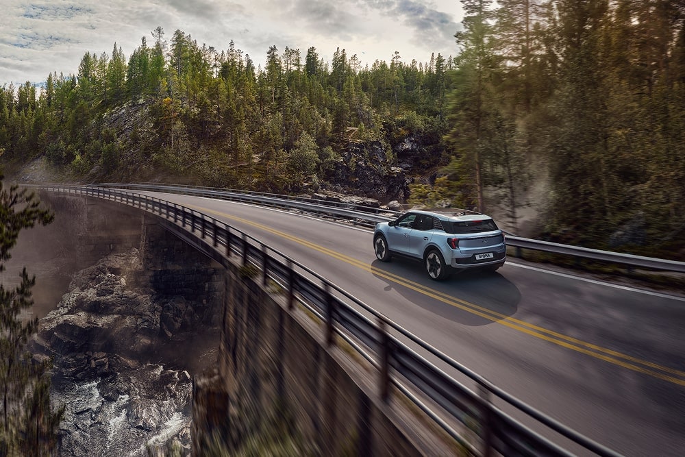 Un Ford Explorer familiar SUV azul recorre un paraje montañoso.