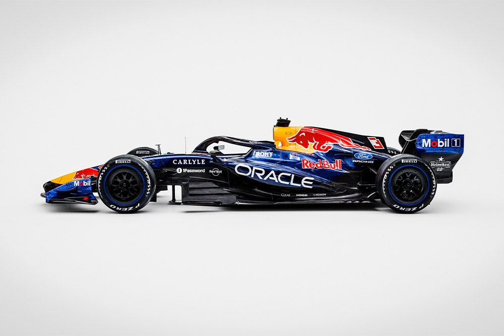 Un elegante monoplaza de Fórmula 1 de Red Bull Ford sobre un fondo blanco liso con los logotipos de los patrocinadores Ford y Red Bull.
