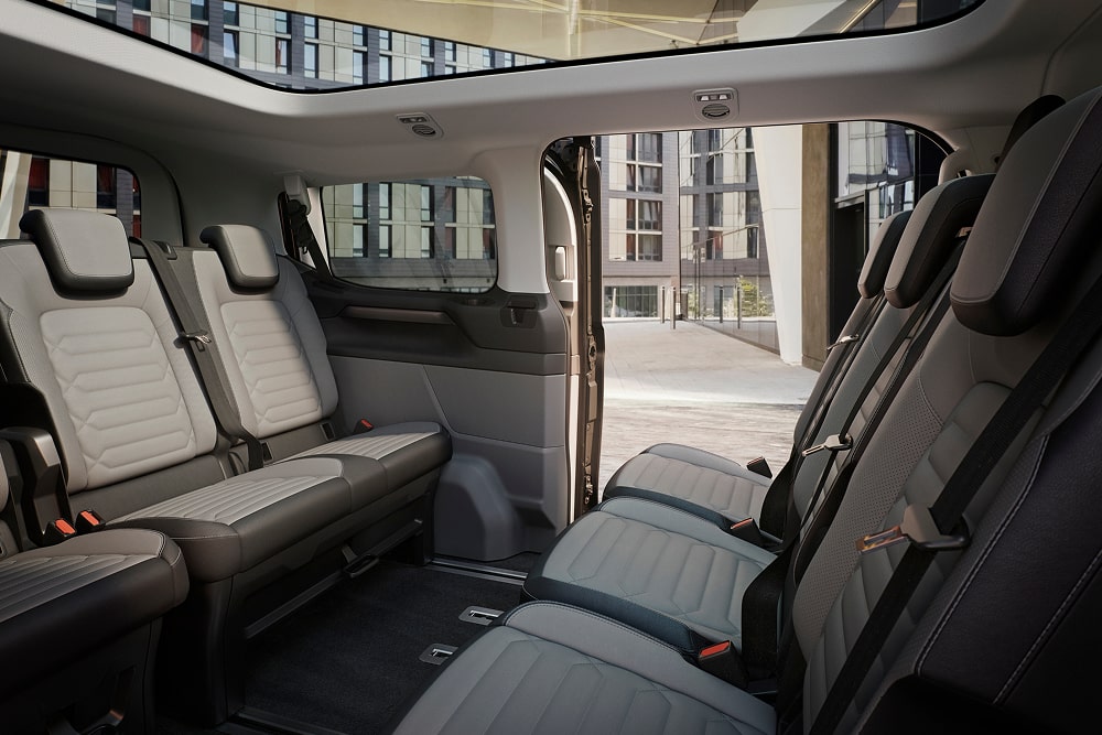 Imagen de las tres filas de asientos flexibles en el interior de un vehículo de transporte de pasajeros Ford Tourneo Custom.