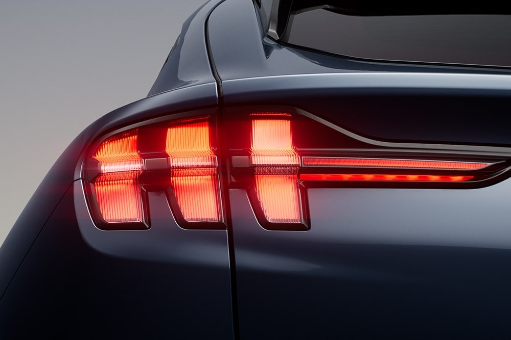 Primer plano de los faros traseros triples encendidos de un deportivo Ford Mustang Mach-E.