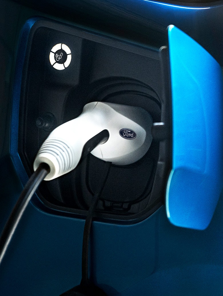 Close-up of a charging cable plugged into an electric vehicle charging port.