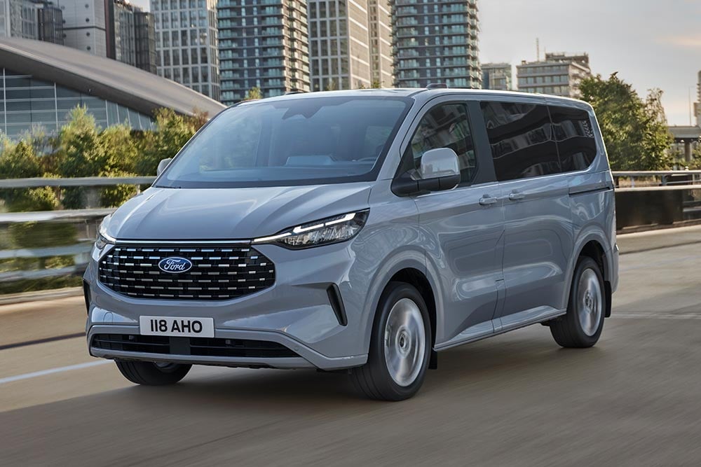 Una Ford Tourneo Custom plateada discurre por una calle de la ciudad.