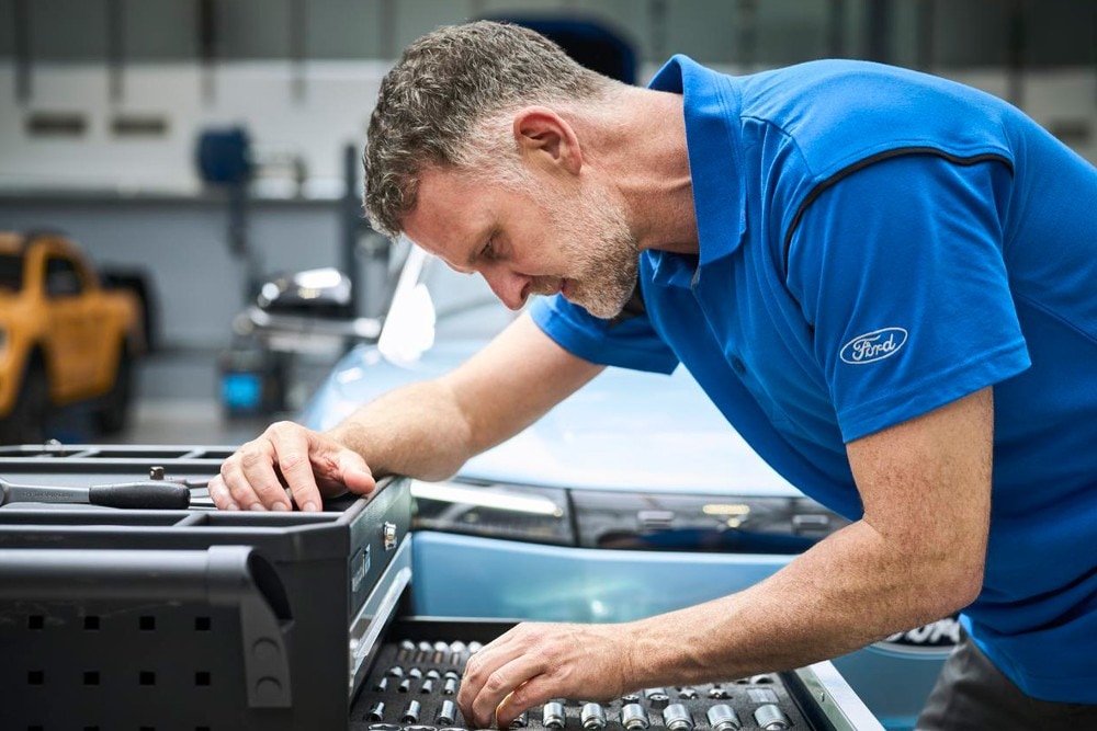 Técnico de servicio de Ford revisando un motor de arranque