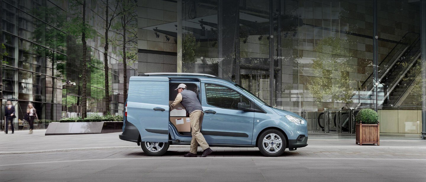 Blue Ford Transit Courier with delivery man